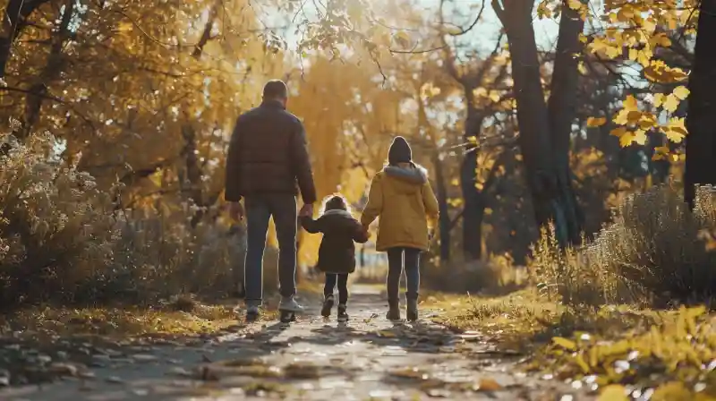 Un homme qui se promène dans un parc avec ses deux enfants